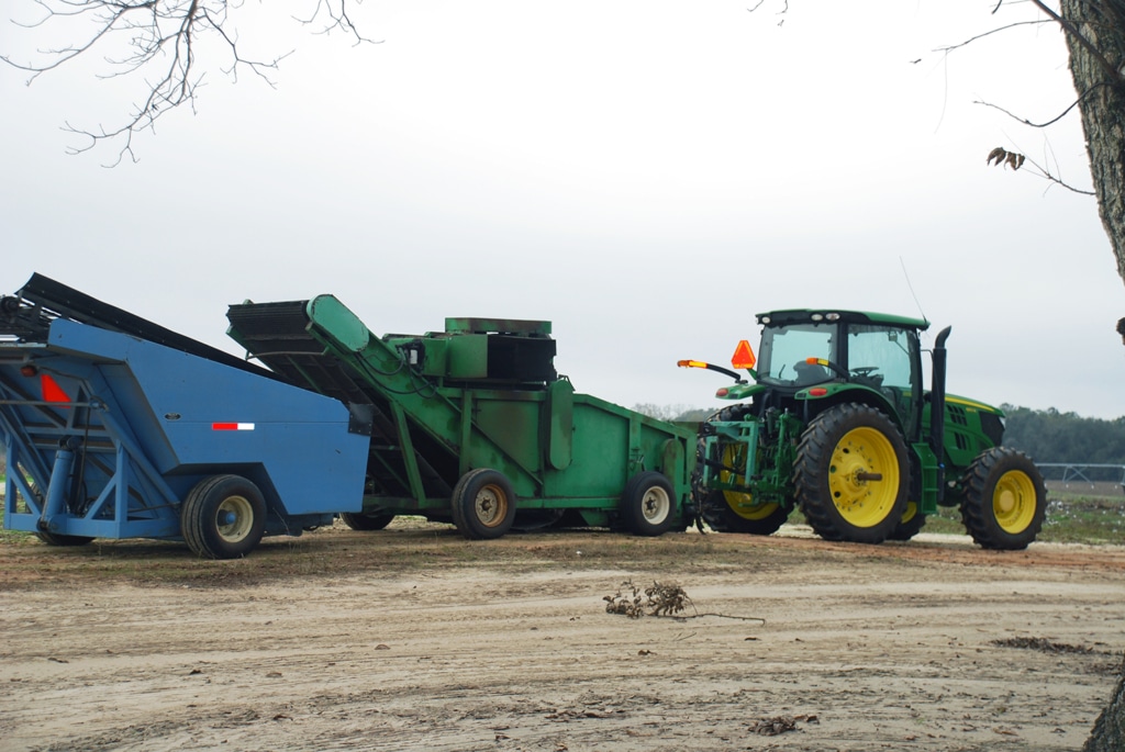 Tractor towing pecan harvesting equipement.